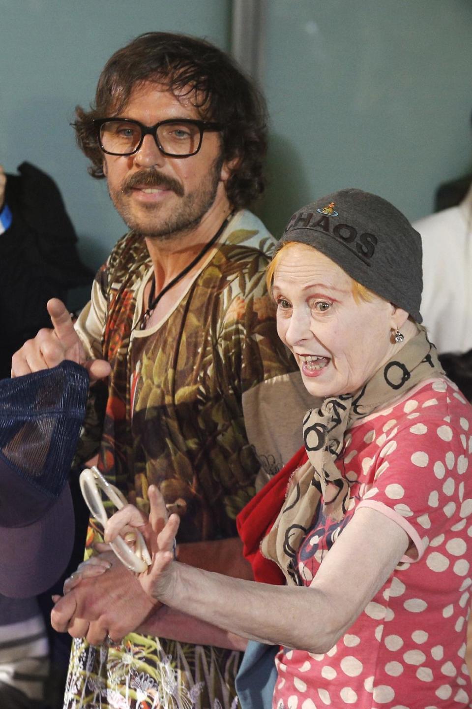 Fashion designer Vivienne Westwood, right, and Andreas Kronthaler acknowledge applause following the presentation of Westwood's ready-to-wear Spring/Summer 2014 fashion collection, presented Saturday, Sept. 28, 2013 in Paris. (AP Photo/Christophe Ena)