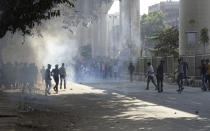 People run for cover as police fire tear gas after clashes between two groups in New Delhi, India, Monday, Feb. 24, 2020. Indian paramilitary troops used tear gas and smoke grenades to disperse a crowd of clashing protesters in New Delhi on Monday as violence broke out over a new citizenship law just ahead of U.S. President Donald Trump’s visit to the city. (AP Photo/Dinesh Joshi)