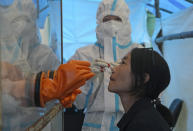 A health worker takes a nasal swab sample to test for COVID-19 in Kohima, capital of the northeastern Indian state of Nagaland, Saturday, Oct. 10, 2020. India’s total coronavirus positive cases near 7 million with another 73,272 infections reported in the past 24 hours. The Health Ministry on Saturday put the total positive caseload at 6.97 million, second to 7.66 million infections registered in the worst-hit United States. (AP Photo/Yirmiyan Arthur)