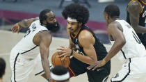 Cleveland Cavaliers' Jarrett Allen, center, drives between Brooklyn Nets' James Harden, left, and Reggie Perry, right, during the first half of an NBA basketball game, Wednesday, Jan. 20, 2021, in Cleveland. (AP Photo/Tony Dejak)