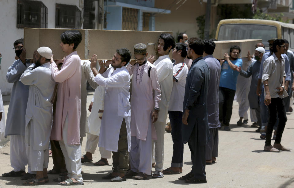 People carry the casket of the victims of Friday's plane crash for funeral prayers in Karachi, Pakistan, Saturday, May 23, 2020. An aviation official says a passenger plane belonging to state-run Pakistan International Airlines carrying passengers and crew has crashed near the southern port city of Karachi. (AP Photo/Fareed Khan)