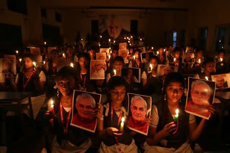 Schoolgirls hold candles and photographs of India's former prime minister Atal Bihari Vajpayee to pay him homage during a prayer ceremony inside a school in Chennai, India, August 16, 2018. REUTERS/P. Ravikumar