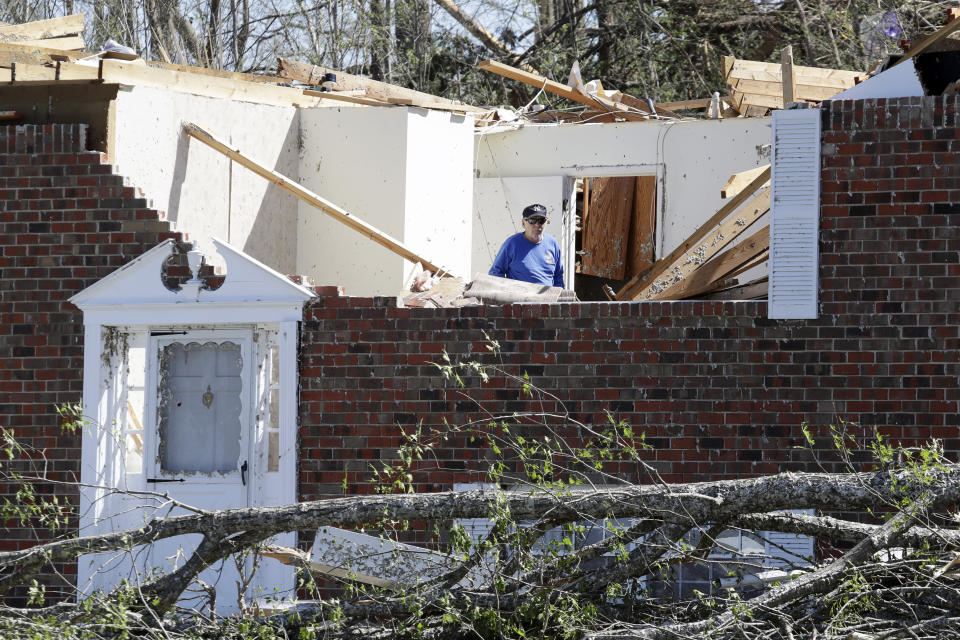 A man walks through a storm-damaged home Tuesday, April 14, 2020, in Chattanooga, Tenn. Tornadoes went through the area Sunday, April 12. (AP Photo/Mark Humphrey)