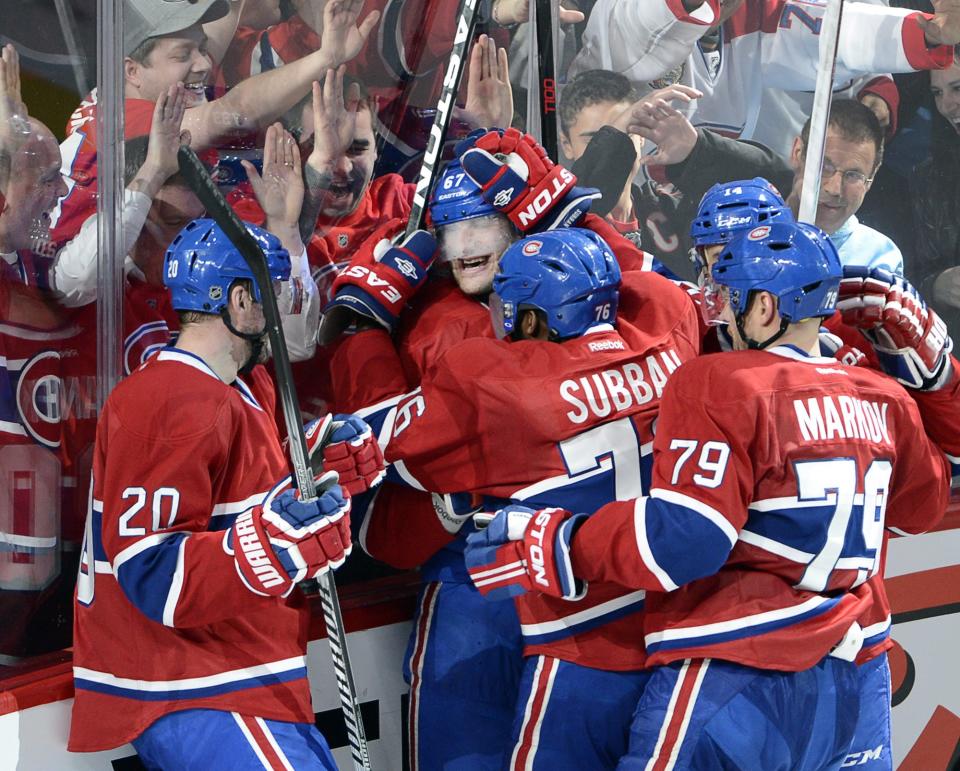 Montreal Canadiens left wing Max Pacioretty (67) is mobbed by teammates after scoring the winning goal against the Tampa Bay Lightning during third period National Hockey League Stanley Cup playoff action on Tuesday, April 22, 2014 in Montreal. (AP Photo/The Canadian Press, Ryan Remiorz)