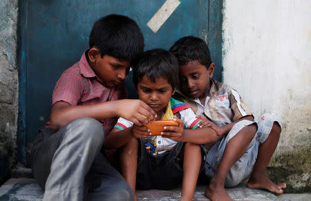 FILE PHOTO: Children play a game on a mobile phone at slum area in New Delhi, India July 4, 2017. REUTERS/Adnan Abidi