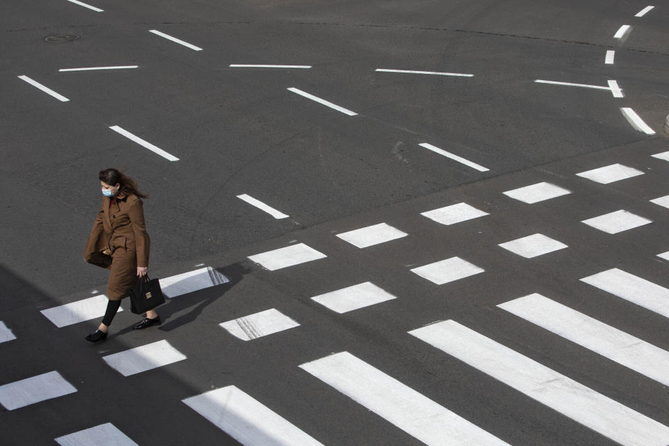 Una mujer israelí con mascarilla cruza la calle en Tel Aviv, Israel, el 1 de abril de 2020. (AP Foto/Sebastian Scheiner)