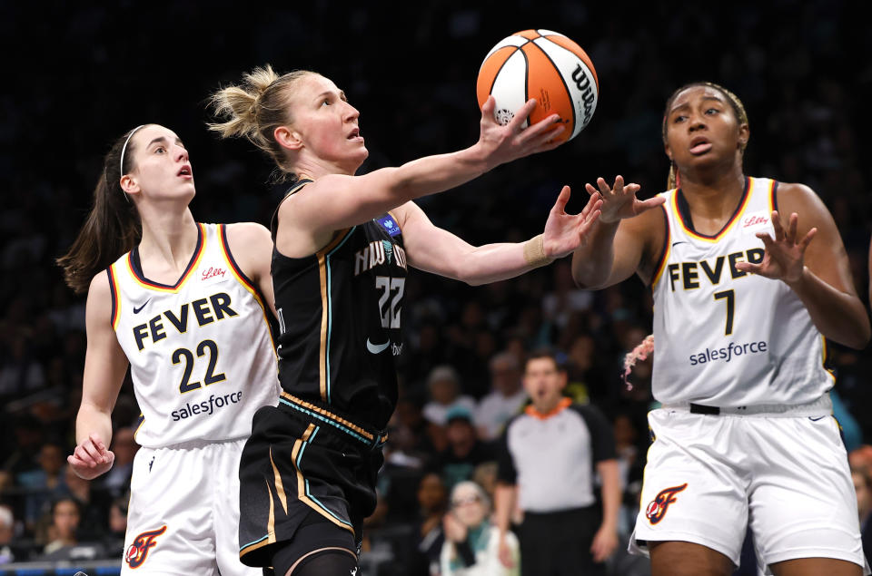 New York Liberty guard Courtney Vandersloot (22) drives to the basket passt Indiana Fever guard Caitlin Clark (22) and forward Aliyah Boston (7) during the second half of a WNBA basketball game, Saturday, May 18, 2024, in New York. The New York Liberty won 91-80. (AP Photo/Noah K. Murray)