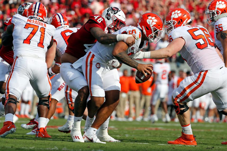 North Carolina State's Cory Durden (48) grabs a hold of Clemson's D.J. Uiagalelei (5) for a sack during the first half of their 2021 game in Raleigh, N.C., Saturday, Sept. 25, 2021.