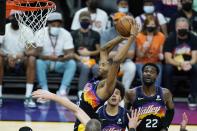 Phoenix Suns forward Mikal Bridges, top left, grabs a rebound against the Los Angeles Clippers as Suns forward Cameron Johnson, center, and center Deandre Ayton, right, look on during the second half of Game 1 of the NBA basketball Western Conference finals Sunday, June 20, 2021, in Phoenix. (AP Photo/Ross D. Franklin)