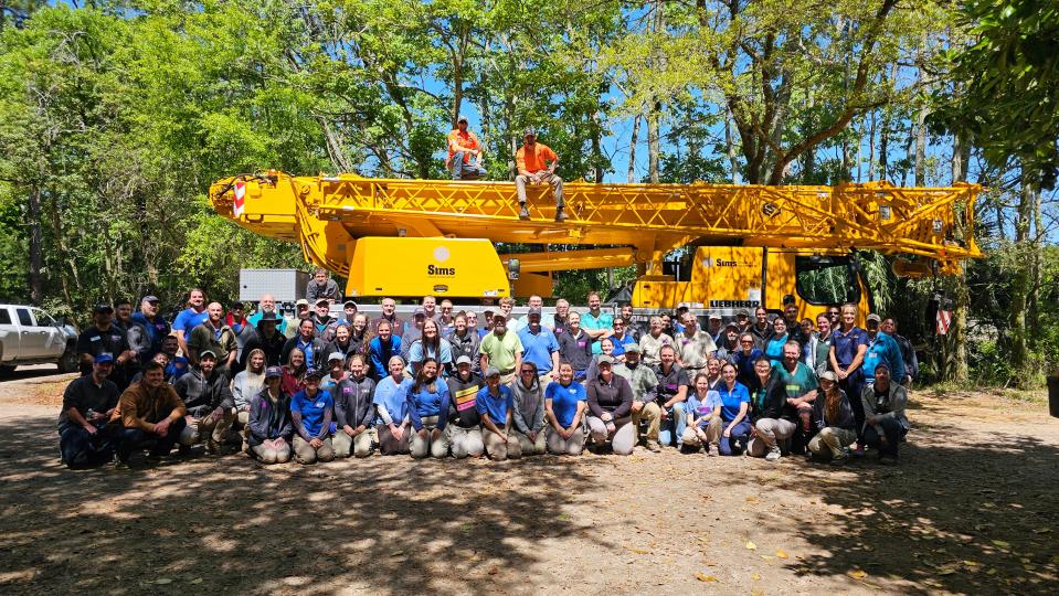 Specialists from as far away as South Africa and India gathered for a group photo at the Jacksonville Zoo and Gardens, where they removed Ali the elephant's infected tusk. The crane behind them was used to help him to his feet after the procedure.