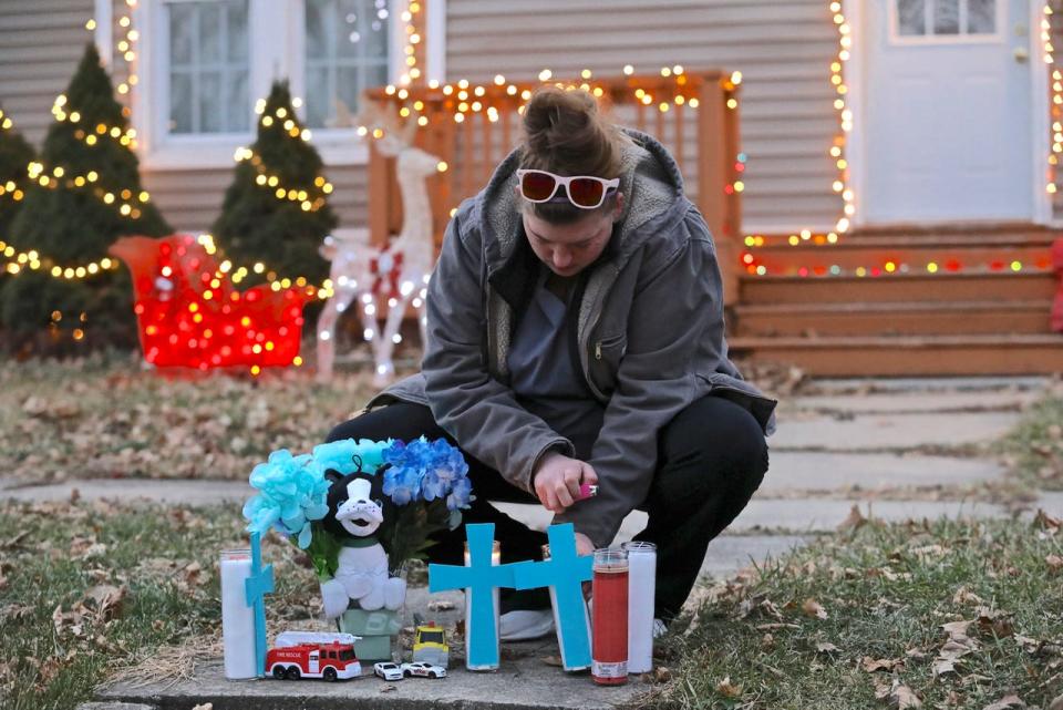Lacey Allison lights candles Tuesday, Dec. 21, 2021, in front of her home in preparation for a candlelight vigil held in memory of homicide victims Andrew Hintt and his two sons, Benjamin, 7, and Sebastian, 5. All three were found dead Sunday in a residence across the street from Allison's home in the 600 block of Union Avenue in Belvidere.