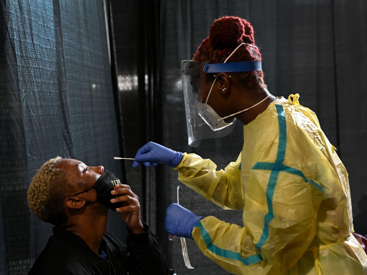 University of Maryland junior Shamar Jackson, 23, left, a Studio Arts major, is tested for the first time for covid-19 by Agnelyne Ndifor, a nursing student at Towson University.