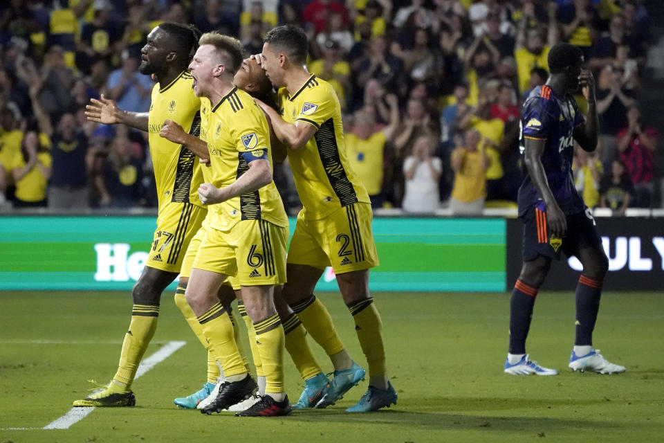 Nashville SC's C.J. Sapong (17), Dax McCarty (6) and Daniel Lovitz (2) celebrate after teammate Hany Mukhtar, center, scored against the Seattle Sounders during the first half of an MLS soccer match Wednesday, July 13, 2022, in Nashville, Tenn. (AP Photo/Mark Humphrey)