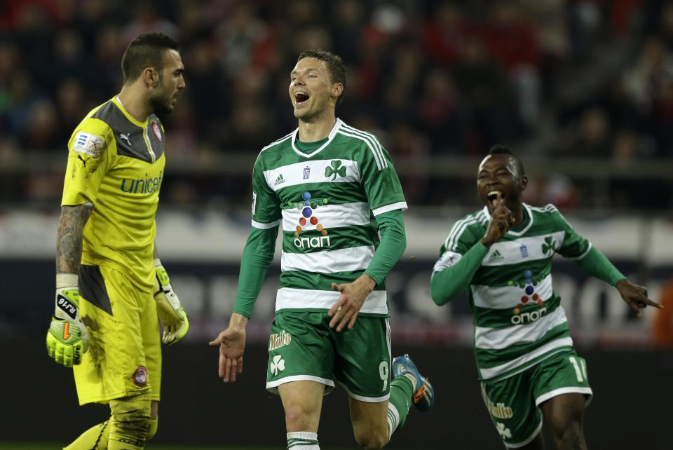 Panathinaikos' Marcus Berg of Sweden, center, celebrates after scoring the second goal of his team against Olympiakos' goalkeeper Roberto of Spain, left, during a Greek League soccer match at Georgios Karaiskakis stadium, in Piraeus port, near Athens, on Sunday, March 2, 2014. (AP Photo/Thanassis Stavrakis)