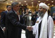 Russian presidential envoy to Afghanistan Zamir Kabulov, left, shake hands with a member of the political delegation from the Afghan Taliban's movement Mawlawi Shahabuddin Dilawar, right, before the opening of talks involving Afghan representatives in Moscow, Russia, Wednesday, Oct. 20, 2021. Russia invited the Taliban and other Afghan parties for talks voicing hope they will help encourage discussions and tackle Afghanistan's challenges. (AP Photo/Alexander Zemlianichenko, Pool)
