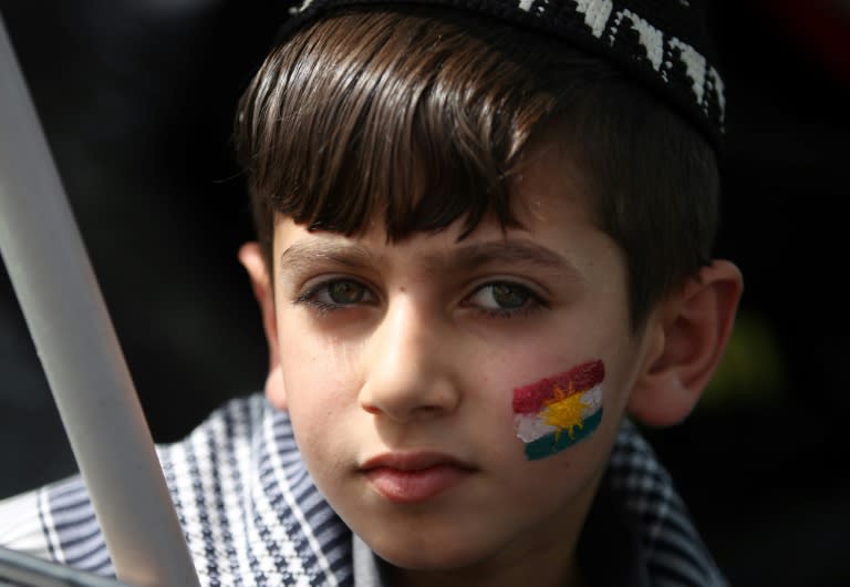 An Iraqi Kurdish boy with the Kurdish flag face-painted on his cheek poses during a celebration in the city of Kirkuk in northern Iraq, on September 25, 2017