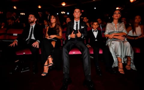 Nominees for the Best FIFA football player, Barcelona and Argentina forward Lionel Messi (L) with his wife Antonella Roccuzzo (2nd L) take their seats next to Real Madrid and Portugal forward Cristiano Ronaldo (C), his son Cristiano Ronaldo Jr (2nd R) and his partner Georgina Rodriguez - Credit: AFP
