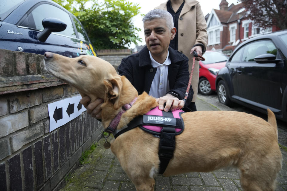 London Mayoral Labour Party candidate Sadiq Khan pats his dog Luna as they pose for the media he arrives to vote in London, Thursday, May 2, 2024. Khan, is seeking re-election, and standing against 12 other candidates for the post of Mayor of London. There are other Mayoral elections in English cities and as well as local council elections. (AP Photo/Kin Cheung)