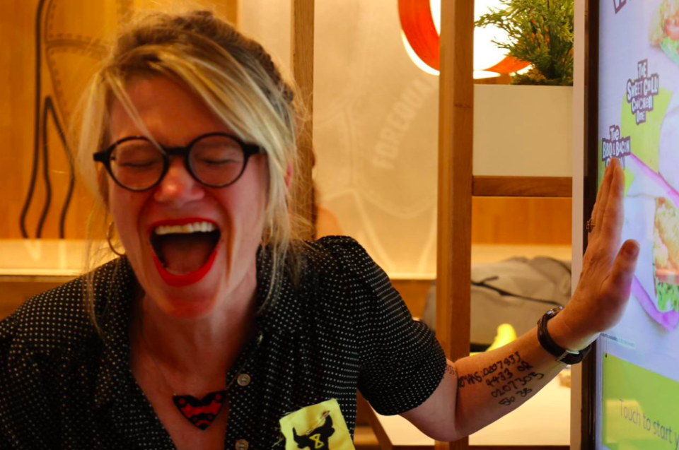 A protester reacts as she glues her hand to a screen inside McDonald's. (Twitter/Animal Rebellion)