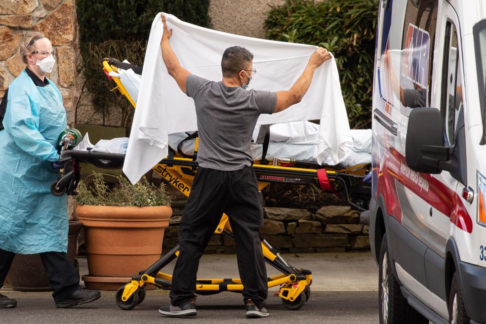 Health-care workers transport a patient into an ambulance at Life Care Center of Kirkland on Feb. 29, 2020, in Kirkland, Wash. Dozens of staff and residents at Life Care Center of Kirkland were reportedly exhibiting coronavirus-like symptoms.