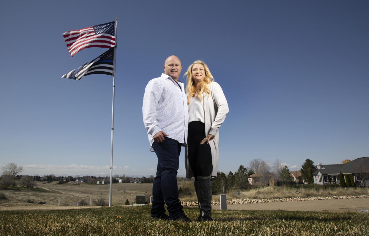 Jennifer and Tim Kohl poses for a photo in their front yard with the American flag and a thin blue line flag in Star, Idaho, on April 14, 2023. The couple recently moved to Idaho from the Los Angeles area. (AP Photo/Kyle Green)