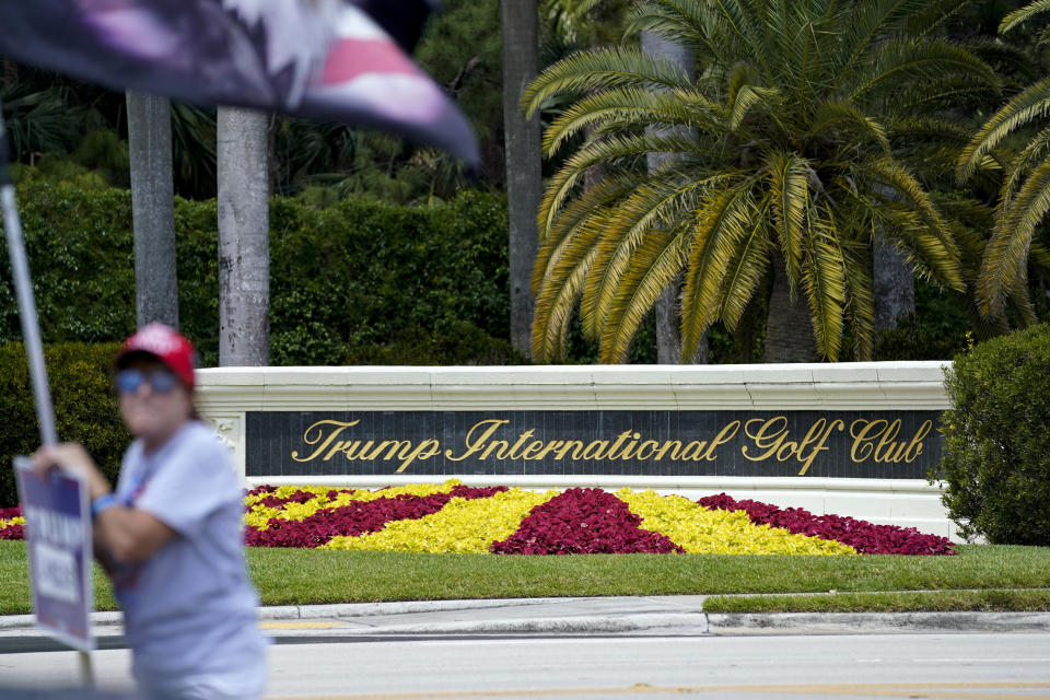 A supporter of former President Donald Trump holds a sign in support of Trump outside Trump International Golf Club, Sunday, April 2, 2023, in West Palm Beach, Fla. (AP Photo/Evan Vucci)