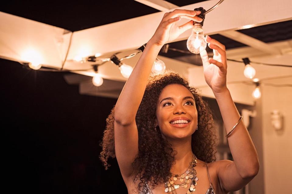 A woman smiles while installing strong lights. 