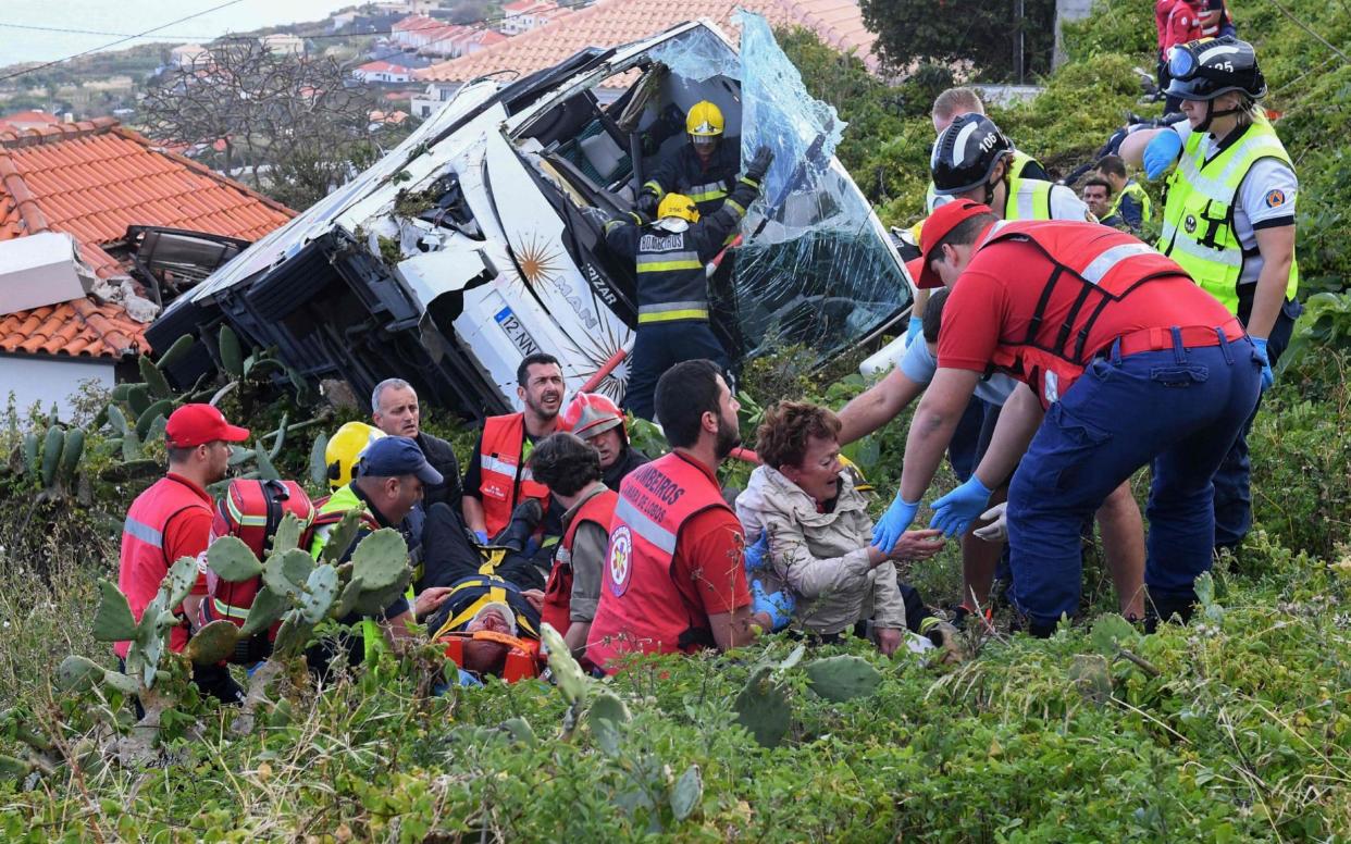 Firemen help victims of a tourist bus that crashed on April 17, 2019 in CaniÃ§o, on the Portuguese island of Madeira - AFP