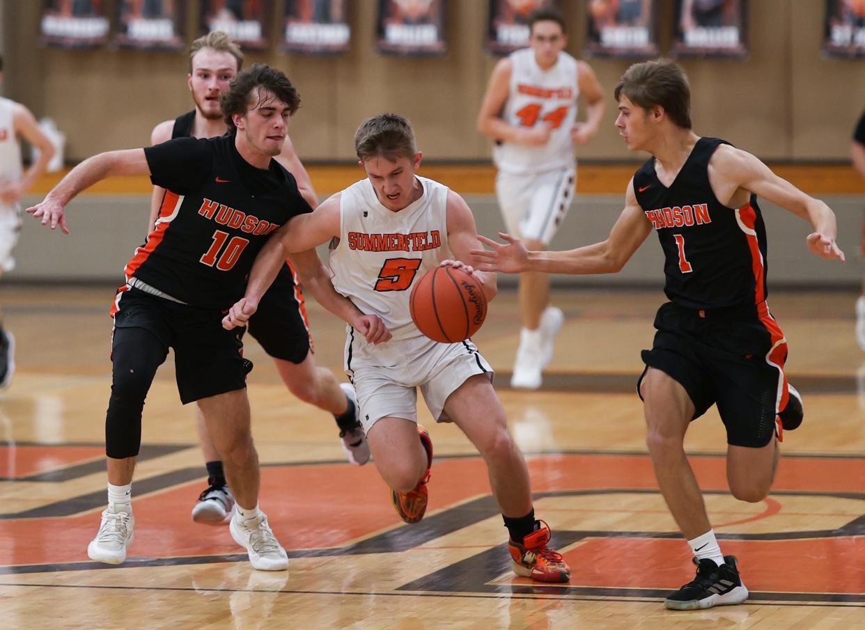 Summerfield's Bryce Kalb tries to split Hudson defenders Ambrose Horwath (left) and Alex Czeiszperger Tuesday night during a 65-37 Hudson win.