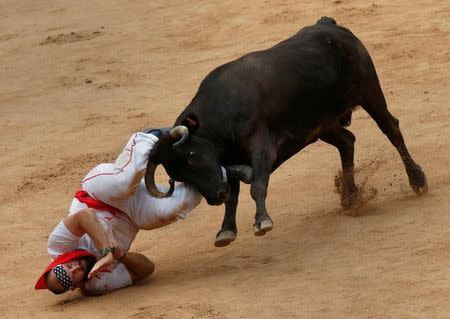 A reveller is tossed by a wild cow following the third running of the bulls at the San Fermin festival in Pamplona, Spain July 9, 2017. REUTERS/Joseba Etxaburu