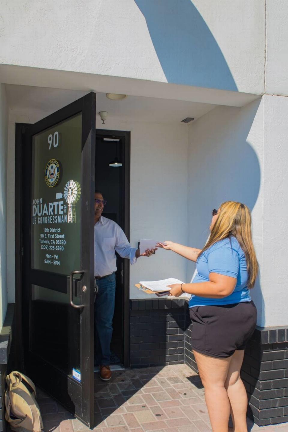 Una organizadora de Valley Families Unite entrega la carta en la que abogan por SNAP al personal de la oficina del distrito del congresista Duarte, el 10 de julio de 2024.