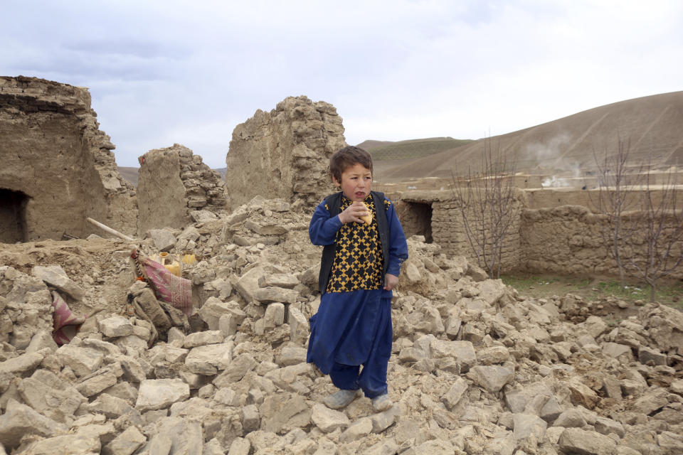 A boy stands near to his damaged house after that was damaged by Monday's earthquake in the remote western province of Badghis, Afghanistan, Tuesday, Jan. 18, 2022. The United Nations on Tuesday raised the death toll from Monday's twin earthquakes in western Afghanistan, saying three villages of around 800 houses were flattened by the temblors. (Abdul Raziq Saddiqi)