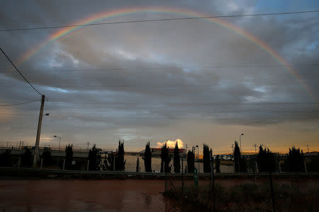 A rainbow is seen over a flooded road, following flash floods which hit the town of Magoula, Greece, June 27, 2018. REUTERS/Costas Baltas