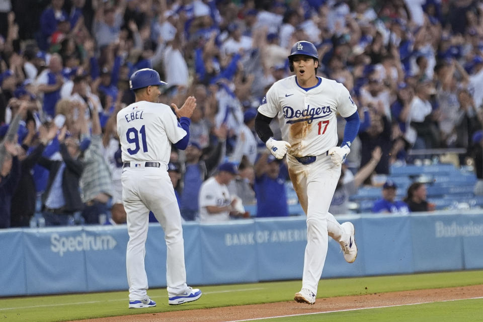 Los Angeles Dodgers' Shohei Ohtani, right, celebrates as he scores on a grand slam by Max Muncy against the Miami Marlins during the first inning of a baseball game Tuesday, May 7, 2024, in Los Angeles. (AP Photo/Marcio Jose Sanchez)