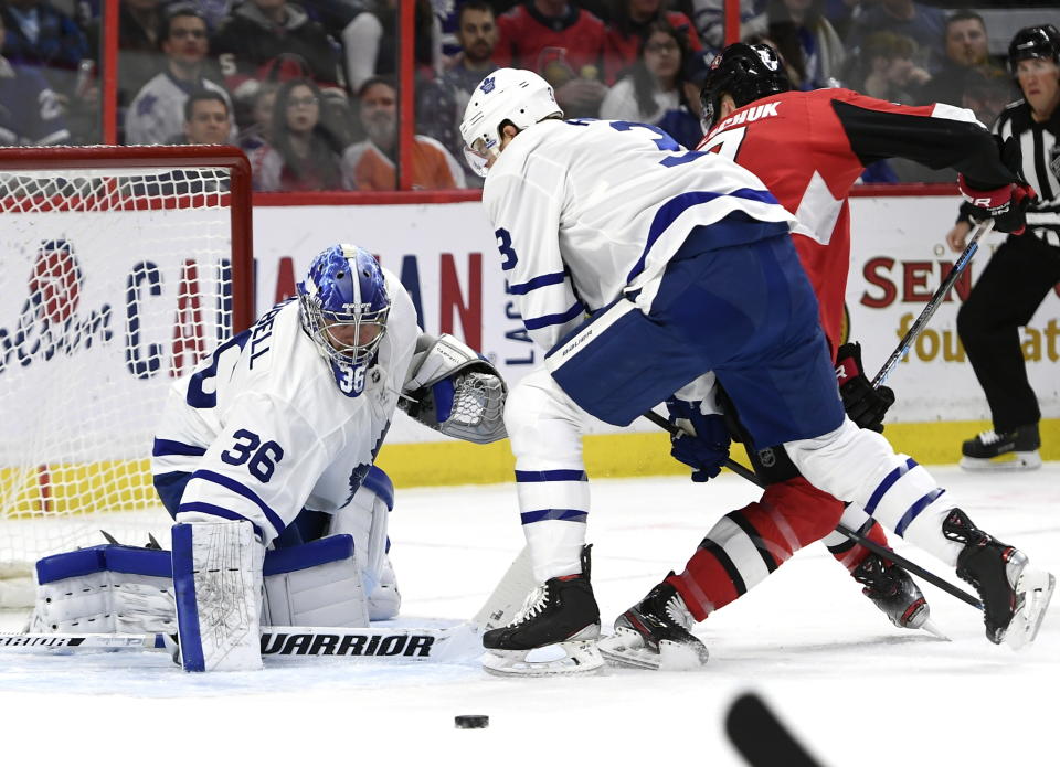 Toronto Maple Leafs goaltender Jack Campbell (36) reaches for the puck as defenseman Justin Holl (3) keeps Ottawa Senators left wing Brady Tkachuk (7) from the puck during first-period NHL hockey game action in Ottawa, Ontario, Saturday, Feb. 15, 2020. (Justin Tang/The Canadian Press via AP)