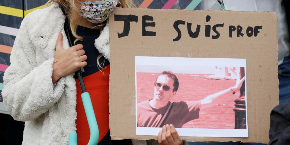 A girl holds a banner with a picture of Samuel Paty, the French teacher who was beheaded on the streets of the Paris suburb of Conflans St Honorine, during a tribute at the Place de la Republique, in Lille, France, October 18, 2020. REUTERS/Pascal Rossignol NO RESALES. NO ARCHIVES.