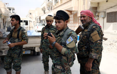 A fighter from Syrian Democratic Forces (SDF) holds a walkie-talkie in Raqqa, Syria September 16, 2017. REUTERS/Rodi Said