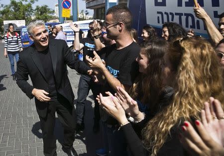 Yesh Atid leader Yair Lapid (L) shakes hands with supporters in Tel Aviv before heading on a campaign tour March 15, 2015. REUTERS/Baz Ratner