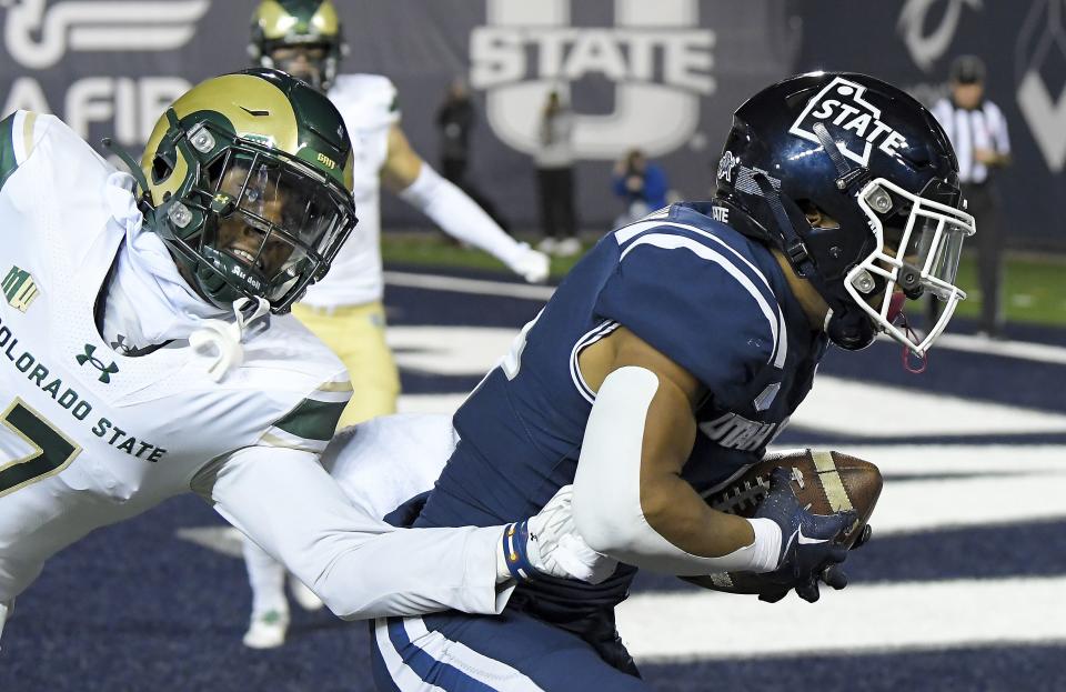 Utah State wide receiver Micah Davis runs with a touchdown reception as Colorado State defensive back Dom Jones defends during the second half of an NCAA college football game Saturday, Oct. 7, 2023, in Logan, Utah. | Eli Lucero/The Herald Journal via AP