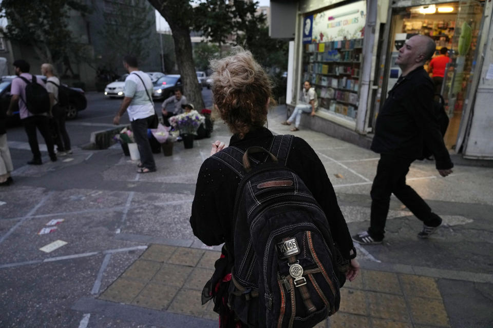 An Iranian woman without wearing her mandatory Islamic headscarf walks in downtown Tehran, Iran, Monday, June 10, 2024. (AP Photo/Vahid Salemi)