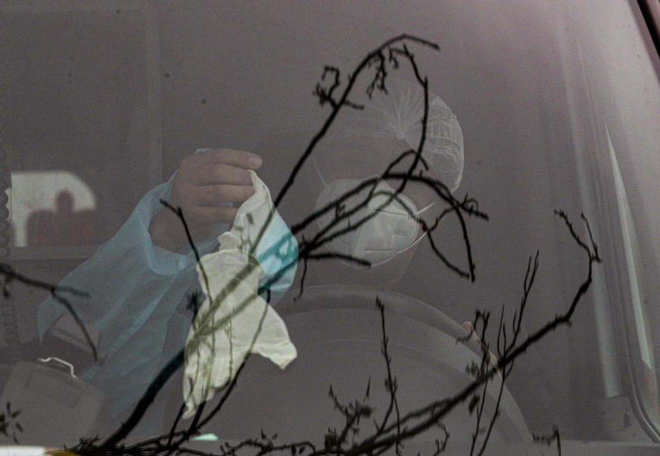 Un trabajador de la salud en una ambulancia usa ropa de protección contra el nuevo coronavirus mientras se dispone a transportar a un paciente con problemas respiratorios en el área de emergencias del hospital San José en Santiago de Chile el miércoles 27 de mayo de 2020. (AP Foto/Esteban Felix)