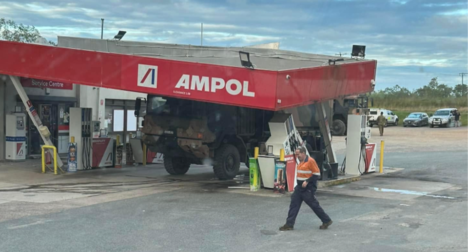 An army truck is seen having barrelled into an Ampol station on the Bruce Highway at Sarina, south of Mackay.