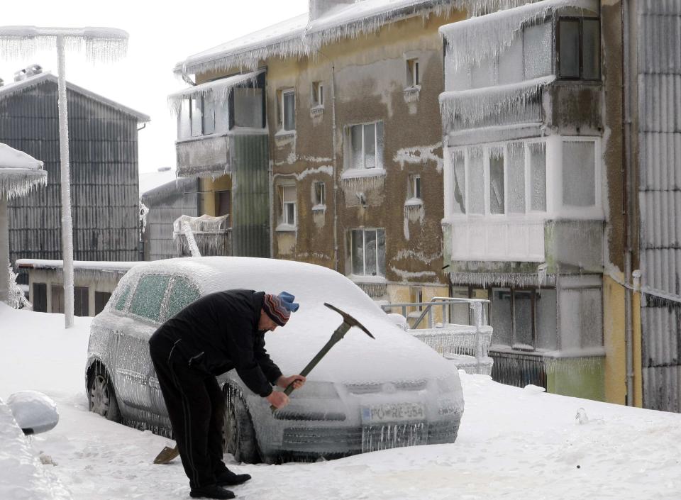 Un hombre buscó remover la capa de hielo en la calle con un pico. REUTERS/Srdjan Zivulovic