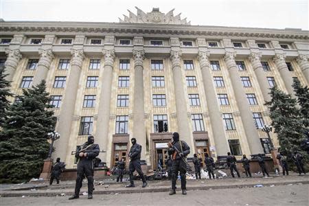 Armed people in masks, representing Ukrainian special forces, stand guard outside the regional administration building in Kharkiv, April 8, 2014. REUTERS/Olga Ivashchenko