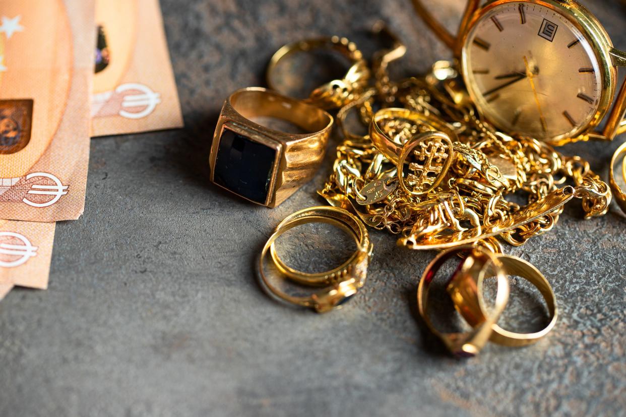 Old and broken jewelry  and on Euro banknotes on dark background. Sell gold for money  concept.