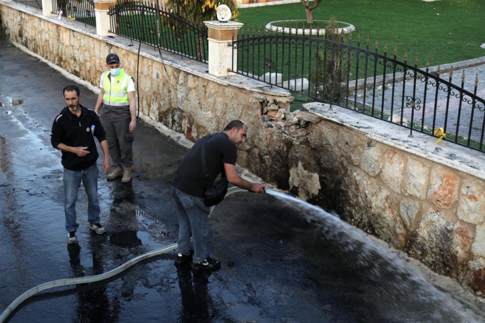 Authorities clear up the aftermath of an Israeli strike that killed a commander of Iran’s proxy group Hezbollah and two others in southern Lebanon on Tuesday (AFP/Getty)