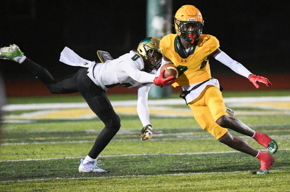 Day Day Farmer of Melbourne Central Catholic gets past Trinity Catholic tackler Courtney Patterson in the FHSAA Region 2-1S football finals November 24, 2023. Craig Bailey/FLORIDA TODAY via USA TODAY NETWORK