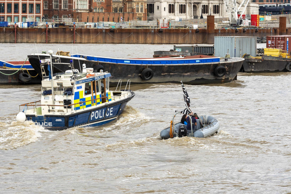  A police launch passes an Extinction Rebellion Marine rib boat on the River Thames during the Extinction Rebellion Macabre Beach Party.
A beach party (on grass) next to the River Thames was held by the Extinction Rebellion Marine supporters to highlight the dangers of the extreme weather caused by climate change and sound an alarm for the urgent need to take action now to avert catastrophic flooding in London, the UK and the whole world. (Photo by Dave Rushen / SOPA Images/Sipa USA) 