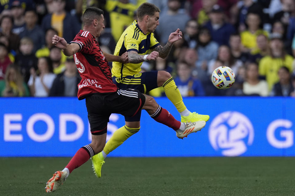 New York Red Bulls defender Sean Nealis, left, and Nashville SC forward Tyler Boyd, right, chase a loose ball during the first half of an MLS soccer match Sunday, Feb. 25, 2024, in Nashville, Tenn. (AP Photo/George Walker IV)