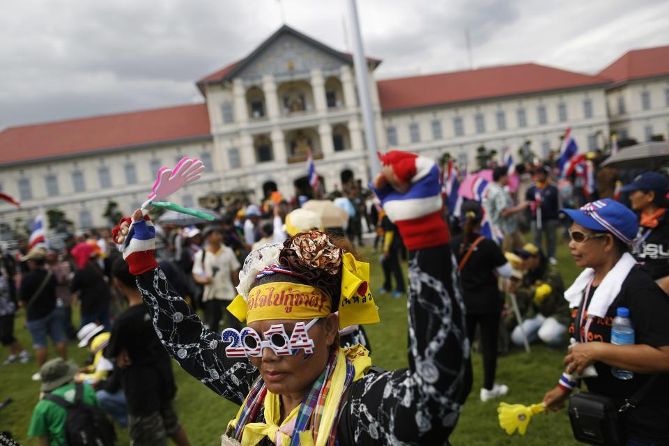 Anti-government protesters cheer after breaking into the compound of the Royal Thai Army headquarters in Bangkok